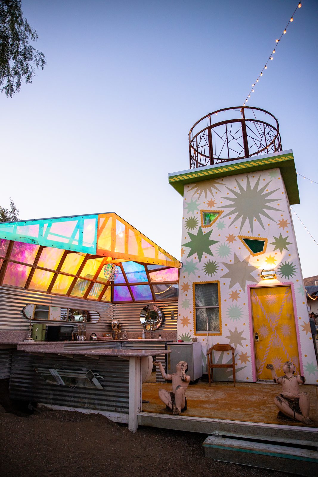 Tijuana Tony’s stained glass roof over the outdoor kitchen at dusk, wood-framed panels of pink, gold and turquoise glowing beside the star tower