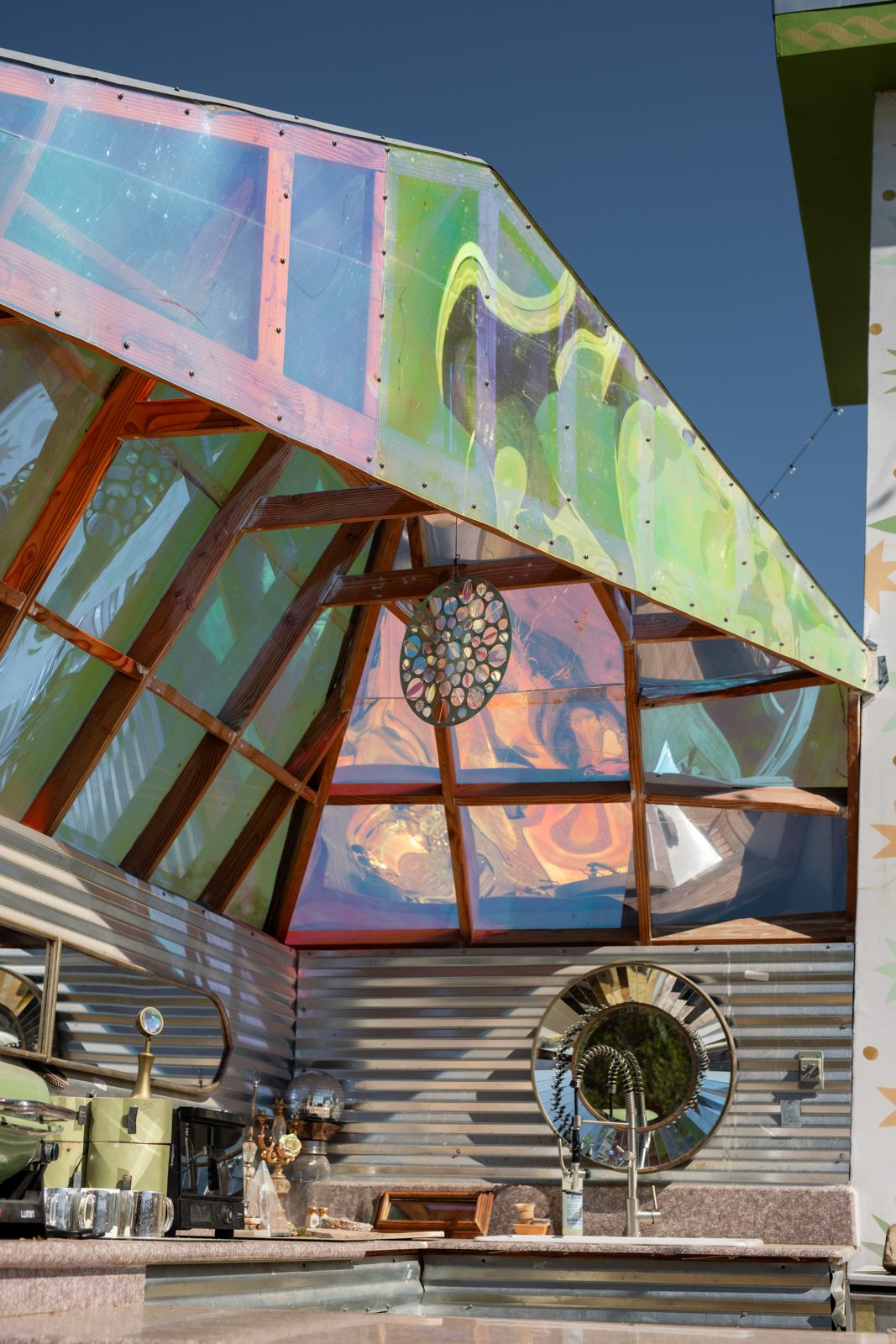 The outdoor kitchen under a roof of iridescent glass